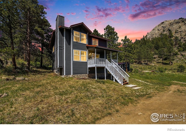 60 Horn Peak Dr, Livermore, CO 80536 - back of house at dusk featuring a chimney, a porch, and stairs