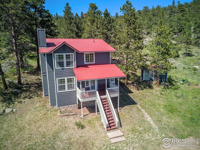 60 Horn Peak Dr, Livermore, CO 80536 - view of front of property featuring a chimney, metal roof, a forest view, stairway, and a front lawn