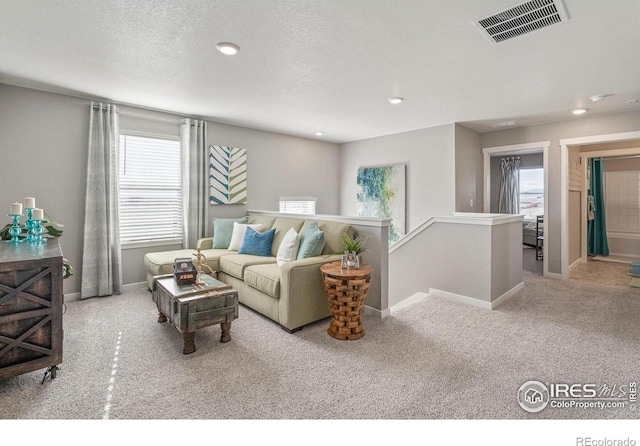 carpeted living room with recessed lighting and baseboards
