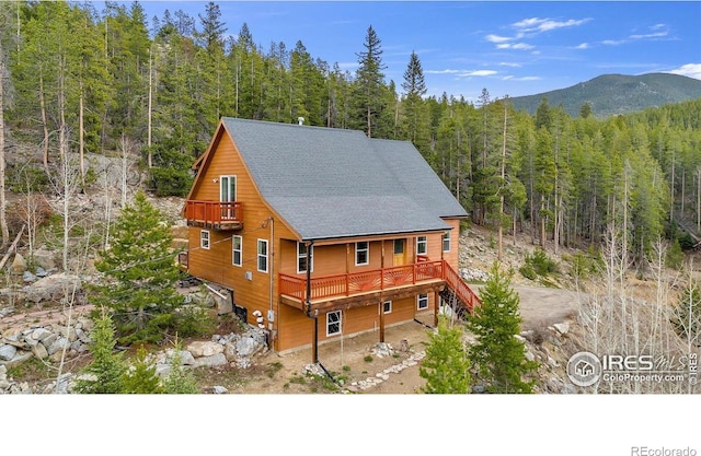 65 La Chula Rd, Black Hawk, CO 80422 - view of home's exterior with a view of trees, roof with shingles, a deck with mountain view, and stairway