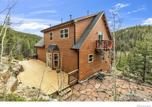 65 La Chula Rd, Black Hawk, CO 80422 - back of house with a wooded view, roof with shingles, and a deck