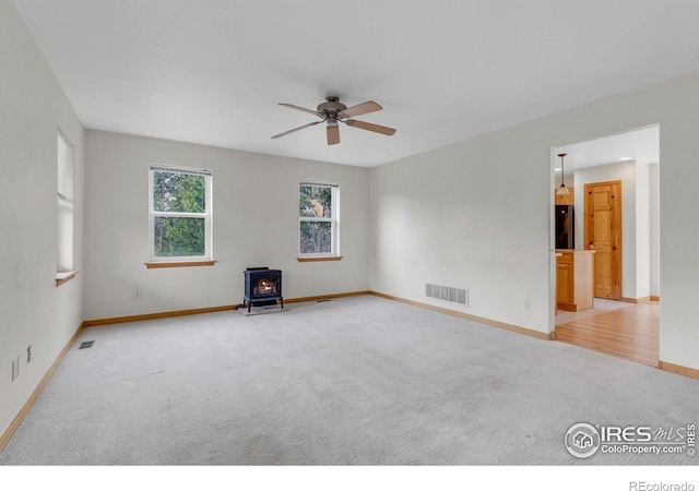 65 La Chula Rd, Black Hawk, CO 80422 - unfurnished room with a wood stove, light carpet, a ceiling fan, and baseboards