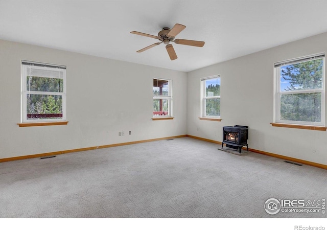 65 La Chula Rd, Black Hawk, CO 80422 - unfurnished room featuring a wood stove, carpet flooring, baseboards, and ceiling fan
