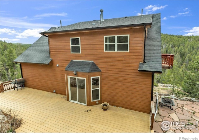 65 La Chula Rd, Black Hawk, CO 80422 - rear view of house with a view of trees, a wooden deck, and roof with shingles