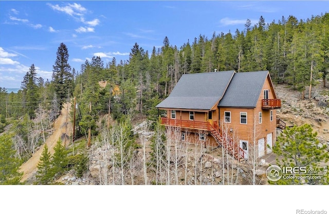 65 La Chula Rd, Black Hawk, CO 80422 - view of front facade featuring a wooded view, stairway, and an attached garage