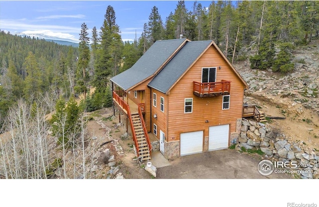 65 La Chula Rd, Black Hawk, CO 80422 - rustic home with a forest view, stairs, an attached garage, and asphalt driveway