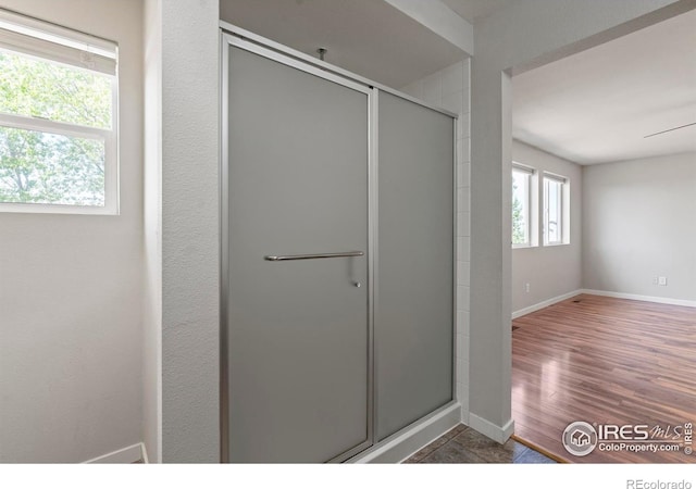 10069 Richfield St, Commerce City, CO 80022 - bathroom featuring a shower stall, baseboards, and wood finished floors