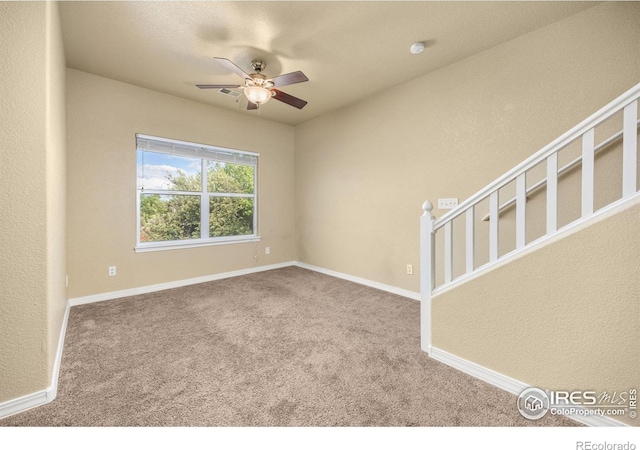 spare room with carpet flooring, ceiling fan, and baseboards