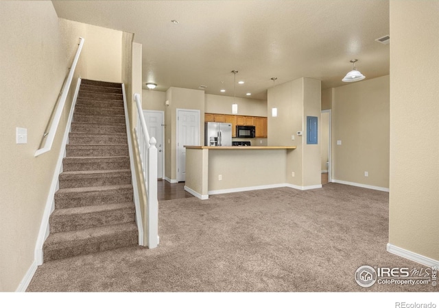 kitchen featuring stainless steel fridge, black microwave, carpet flooring, baseboards, and decorative light fixtures