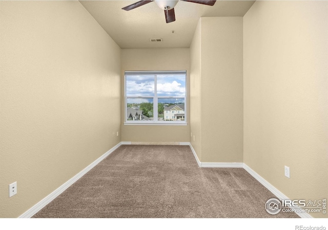 spare room with carpet, a ceiling fan, and baseboards