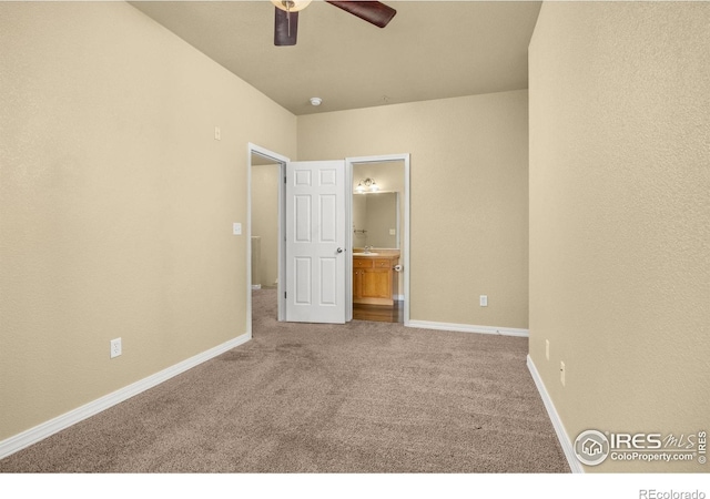 unfurnished bedroom featuring carpet floors, connected bathroom, baseboards, and a ceiling fan