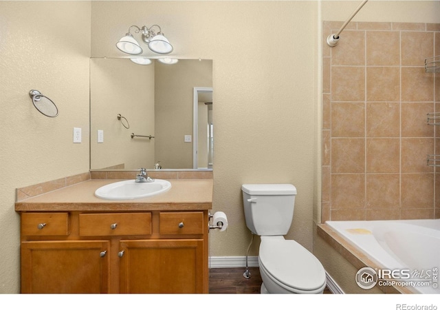 bathroom featuring toilet, vanity, and tiled shower / bath combo