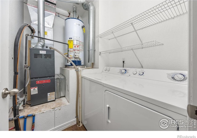 washroom with water heater, washing machine and dryer, wood finished floors, and heating unit