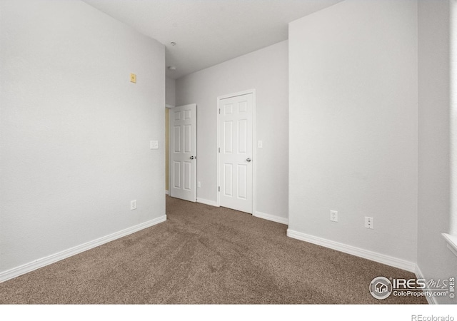 carpeted spare room featuring baseboards