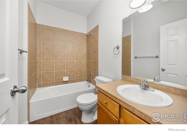 bathroom with wood finished floors, toilet, vanity, and bathtub / shower combination