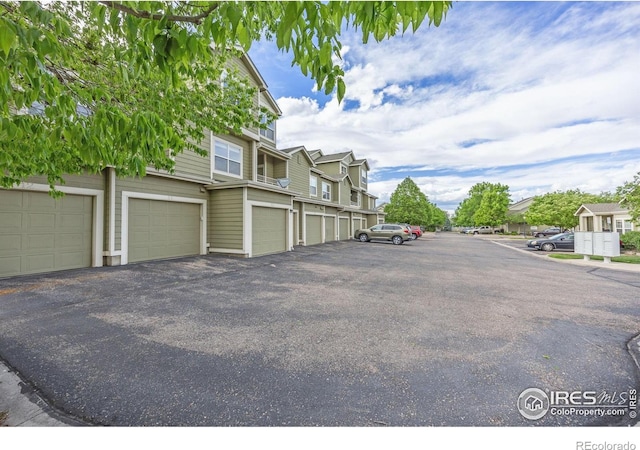 view of asphalt road featuring community garages and a residential view