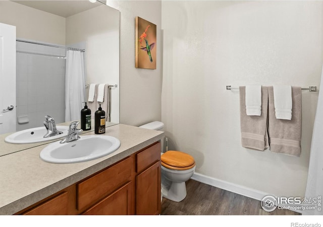 bathroom with toilet, wood finished floors, vanity, baseboards, and a shower with shower curtain