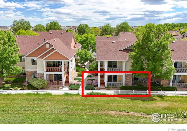 view of front of property with stone siding, stairs, and a balcony
