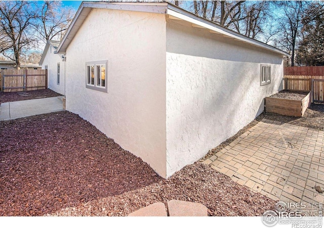 527 S Bryan Ave, Fort Collins, CO 80521 - view of property exterior featuring stucco siding, a fenced backyard, and a patio