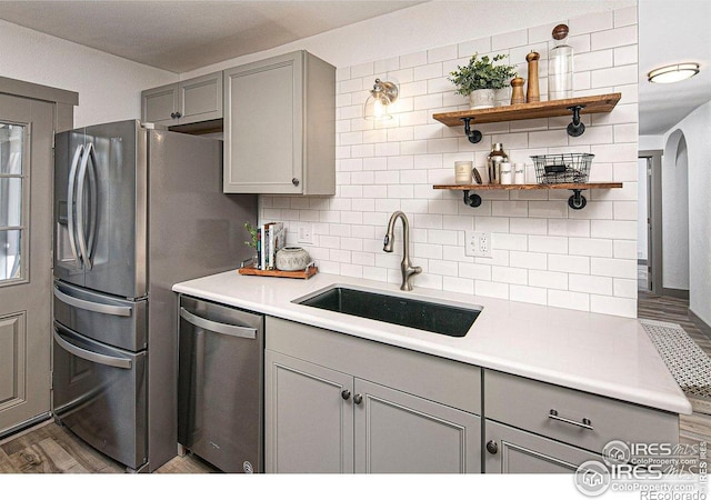 527 S Bryan Ave, Fort Collins, CO 80521 - kitchen featuring dishwasher, gray cabinets, a sink, tasteful backsplash, and wood finished floors