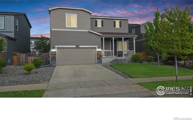 6008 Sandstone Cir, Frederick, CO 80516 - view of front of house with a porch, a garage, concrete driveway, and stone siding