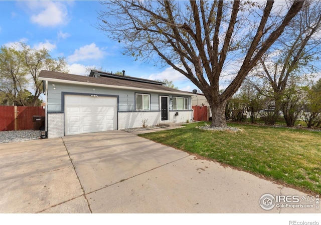 312 21st Avenue Ct, Greeley, CO 80631 - view of front of home with a garage, brick siding, driveway, and solar panels