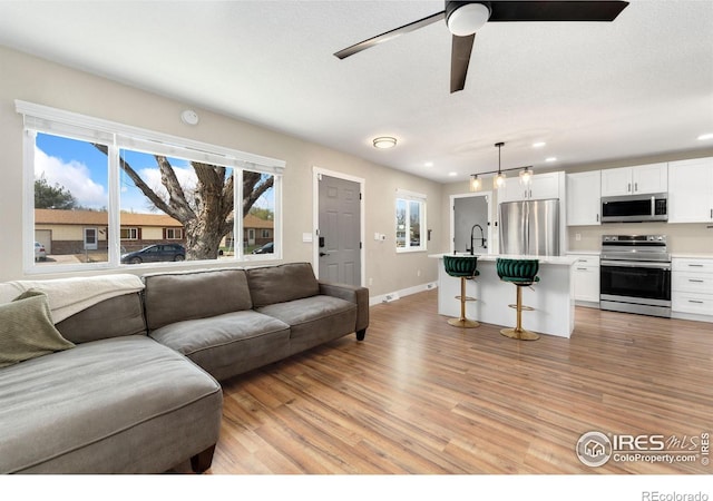312 21st Avenue Ct, Greeley, CO 80631 - living area with light wood finished floors, recessed lighting, ceiling fan, and baseboards