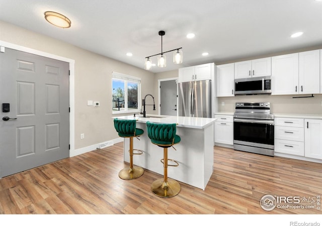 312 21st Avenue Ct, Greeley, CO 80631 - kitchen with appliances with stainless steel finishes, light wood-style floors, white cabinetry, light countertops, and recessed lighting