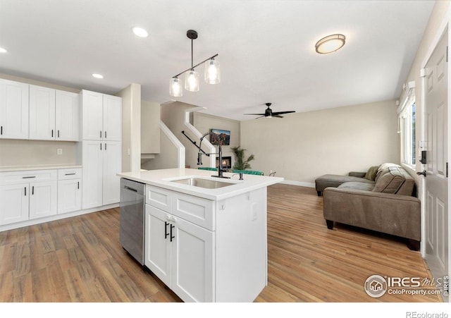 312 21st Avenue Ct, Greeley, CO 80631 - kitchen with stainless steel dishwasher, a sink, open floor plan, ceiling fan, and light wood finished floors