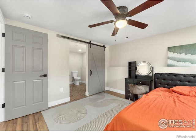 312 21st Avenue Ct, Greeley, CO 80631 - bedroom featuring a barn door, wood finished floors, and baseboards