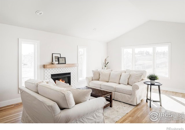 4932 Valkyrie Dr, Boulder, CO 80301 - living area featuring a fireplace, vaulted ceiling, light wood-style flooring, and baseboards