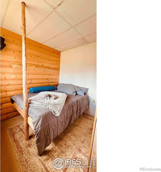 867 Windy Ridge Rd, Red Feather Lakes, CO 80545 - bedroom featuring log walls and a drop ceiling