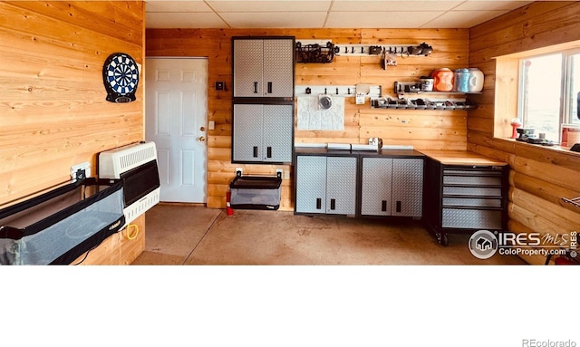 867 Windy Ridge Rd, Red Feather Lakes, CO 80545 - kitchen with heating unit, unfinished concrete flooring, and wooden walls