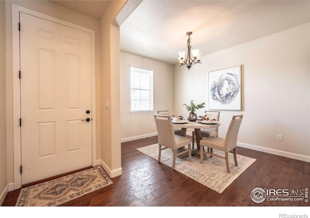 1358 14th Ave, Longmont, CO 80501 - dining space featuring a chandelier, baseboards, and dark wood-style flooring