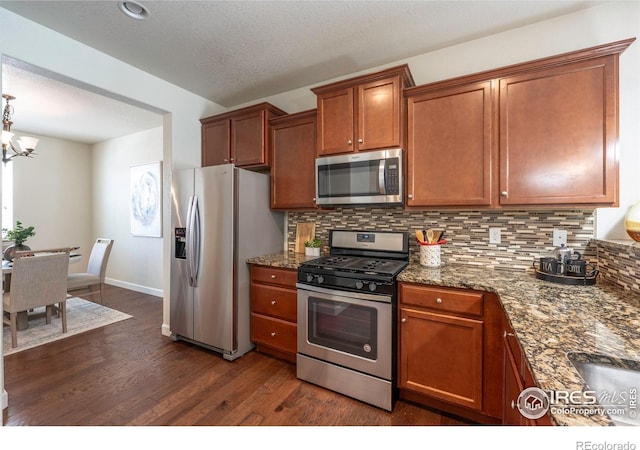 1358 14th Ave, Longmont, CO 80501 - kitchen with appliances with stainless steel finishes, dark wood finished floors, backsplash, and brown cabinetry