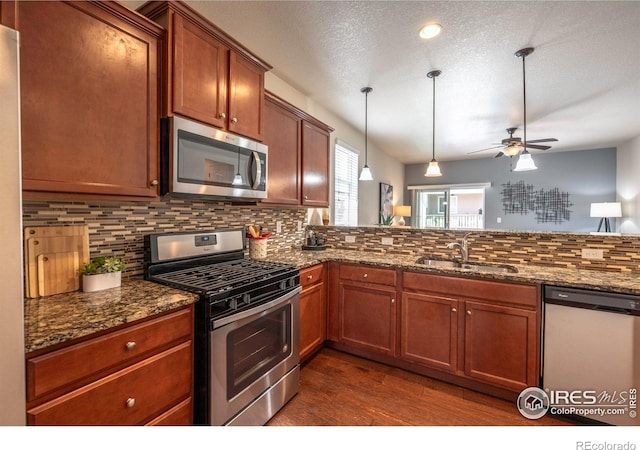 1358 14th Ave, Longmont, CO 80501 - kitchen featuring stainless steel appliances, a sink, dark wood-style floors, a ceiling fan, and tasteful backsplash