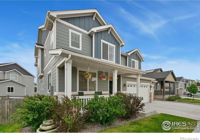 1203 Cabot Ct, Fort Collins, CO 80526 - view of front facade with covered porch, board and batten siding, concrete driveway, and stone siding
