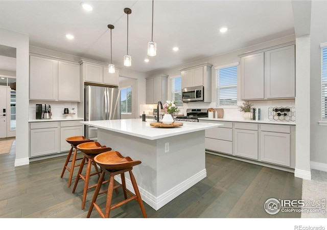1203 Cabot Ct, Fort Collins, CO 80526 - kitchen featuring stainless steel appliances, a kitchen island, dark wood-type flooring, healthy amount of natural light, and recessed lighting