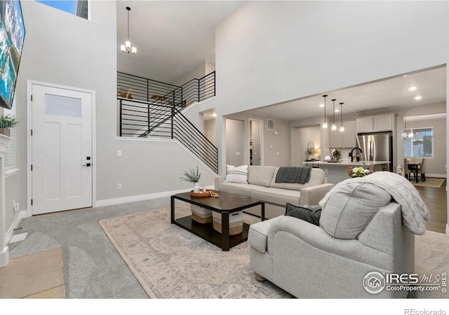 1203 Cabot Ct, Fort Collins, CO 80526 - living area featuring a towering ceiling, a chandelier, stairway, light colored carpet, and baseboards