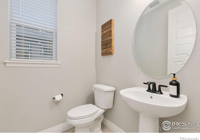 1203 Cabot Ct, Fort Collins, CO 80526 - half bathroom featuring baseboards, toilet, and a sink