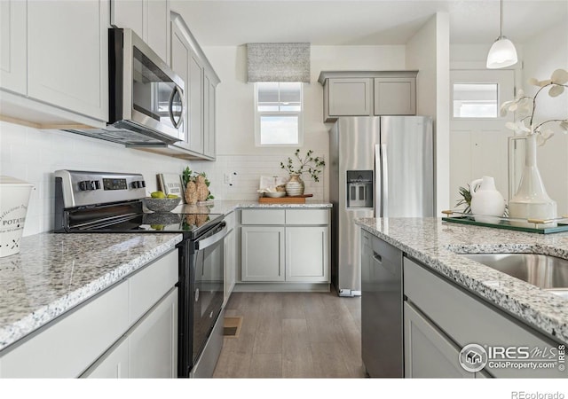 18722 E 99th Ave, Commerce City, CO 80022 - kitchen with stainless steel appliances, plenty of natural light, gray cabinets, and light wood-style flooring