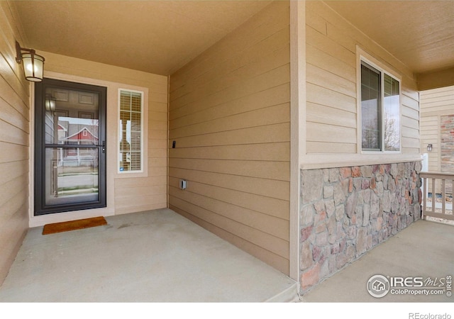 1540 Murrlet St, Berthoud, CO 80513 - doorway to property with covered porch and stone siding