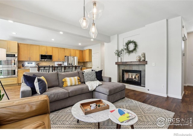4109 Frederick Cir, Longmont, CO 80503 - living room featuring dark wood finished floors, recessed lighting, baseboards, and a tiled fireplace