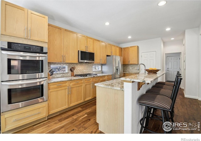 4109 Frederick Cir, Longmont, CO 80503 - kitchen featuring appliances with stainless steel finishes, decorative backsplash, dark wood finished floors, light brown cabinets, and recessed lighting