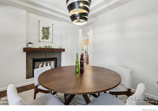 4109 Frederick Cir, Longmont, CO 80503 - dining area featuring a tile fireplace, baseboards, and wood finished floors