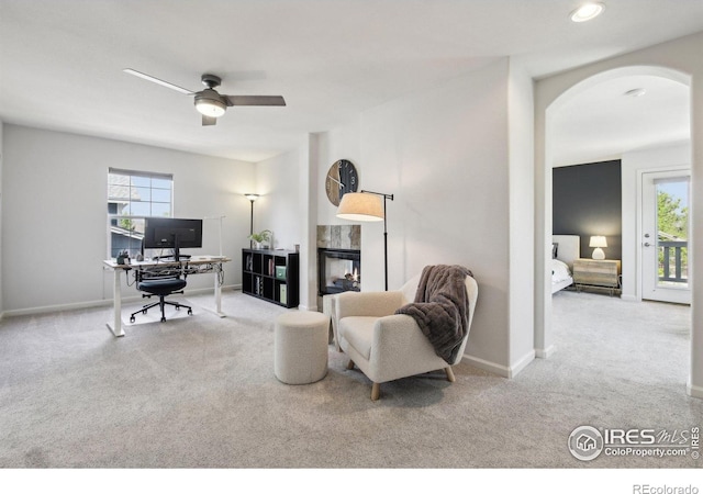4109 Frederick Cir, Longmont, CO 80503 - carpeted living room with arched walkways, an office area, ceiling fan, and baseboards