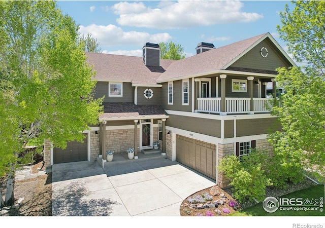 4109 Frederick Cir, Longmont, CO 80503 - view of front of property with an attached garage, concrete driveway, a chimney, and stone siding