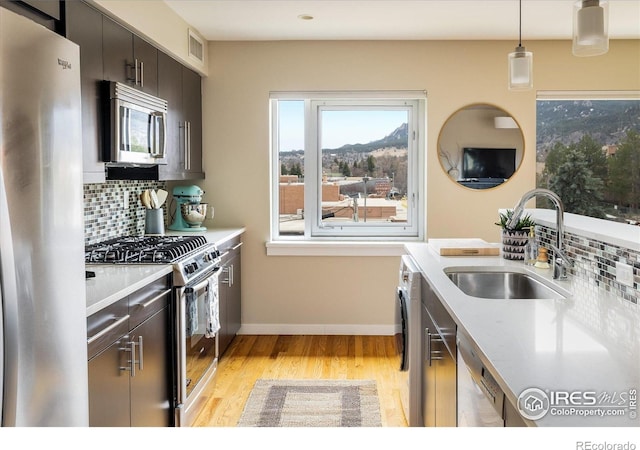 1201 Balsam Ave Unit 302, Boulder, CO 80304 - kitchen with stainless steel appliances, a sink, light countertops, light wood-type flooring, and backsplash