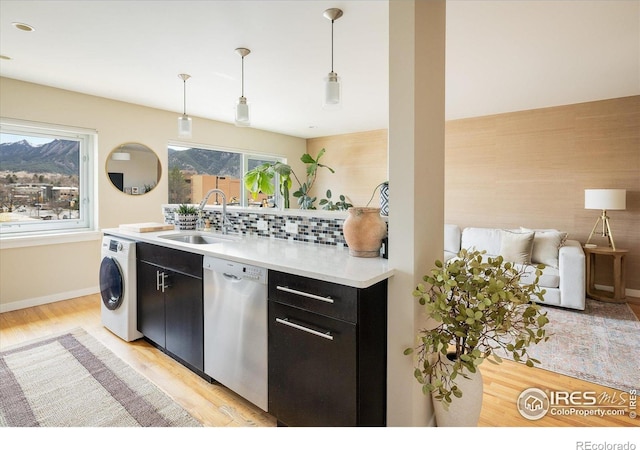 1201 Balsam Ave Unit 302, Boulder, CO 80304 - kitchen with washer / dryer, stainless steel dishwasher, dark cabinets, a sink, and light wood-type flooring