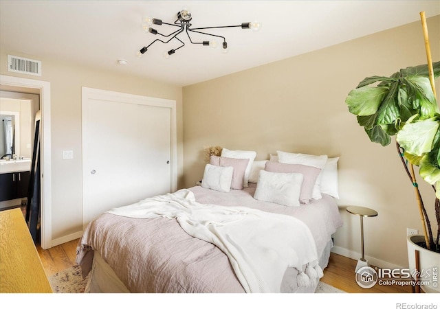 1201 Balsam Ave Unit 302, Boulder, CO 80304 - bedroom with wood finished floors, a closet, baseboards, and a chandelier